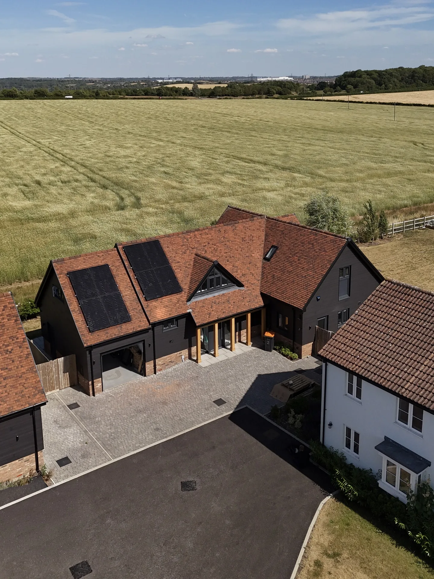 Aerial view of a Bedfordshire countryside home with rooftop solar panels overlooking open fields