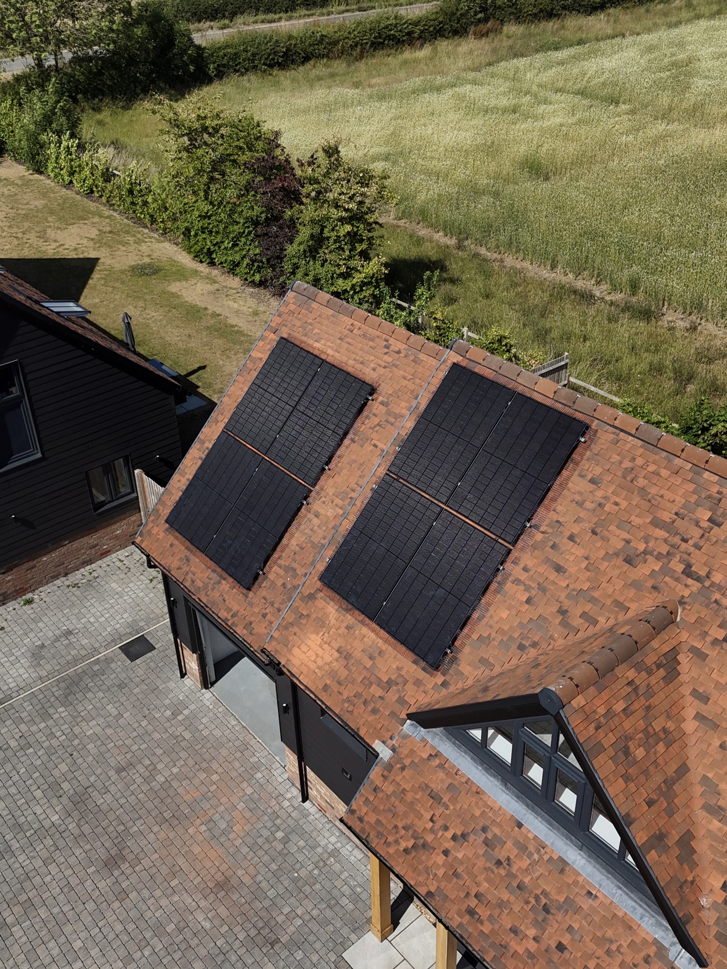 Contemporary home with solar panels on a clay tile roof, aerial view