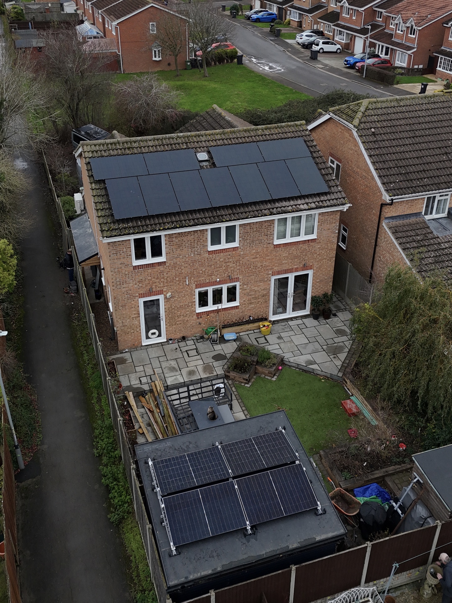 Family home with solar panels on the main roof and a separate garage solar array