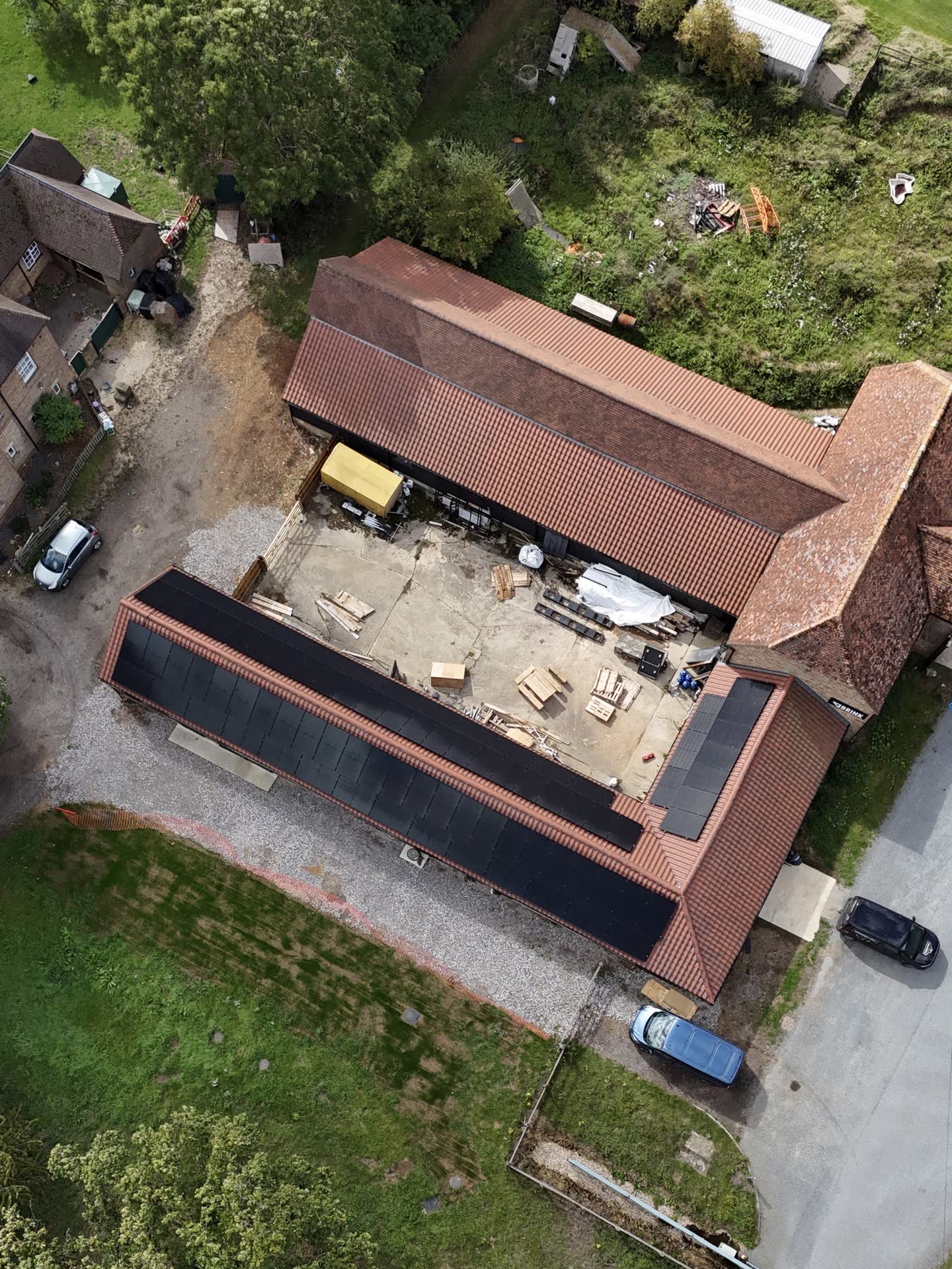 Aerial view of an agricultural barn with rooftop solar panels installed by MJ Renewables