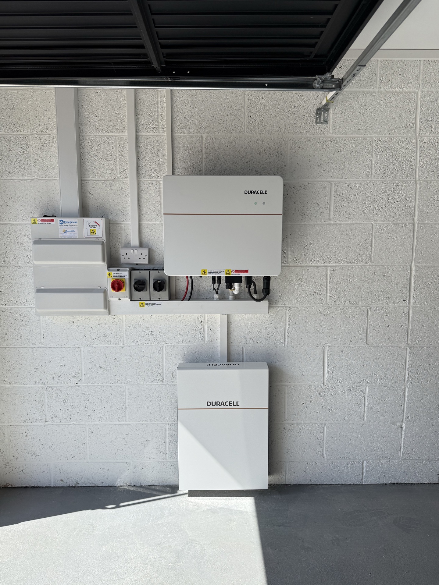 Duracell home battery and inverter mounted to a garage wall with neat cable runs